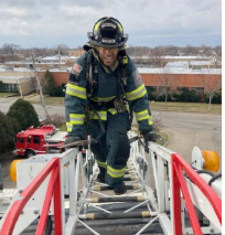 Firefighter walking up ladder